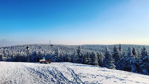 Scenic view of snow covered landscape against clear blue sky