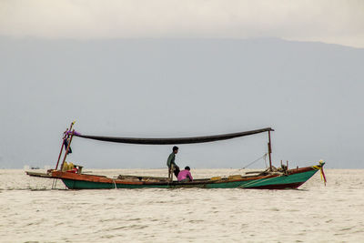 Men on boat sailing in sea 