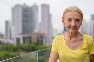 Portrait of smiling mid adult woman in city