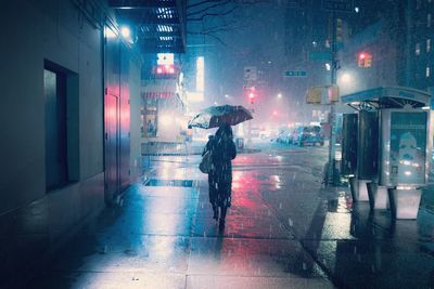 Man on wet street at night