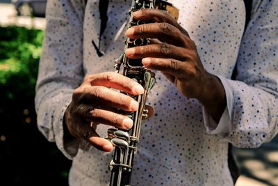 Midsection of man playing saxophone 