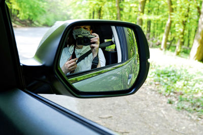 Reflection of woman on side-view mirror