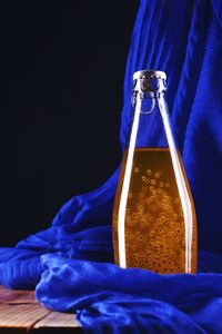 Close-up of glass bottle against blue background