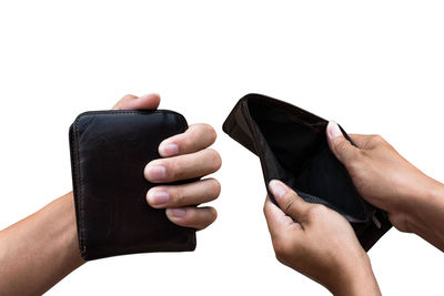 Close-up of man holding hands over white background