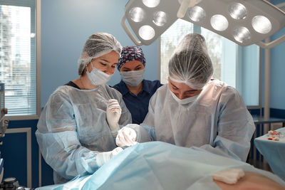 High angle view of female doctor examining patient at home