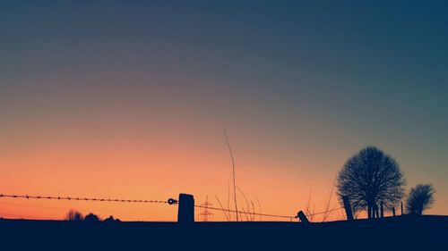 Low angle view of silhouette trees against sky at sunset