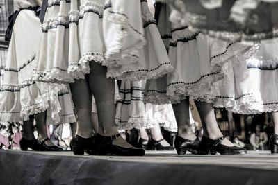 Low section of women in costume standing on road during event