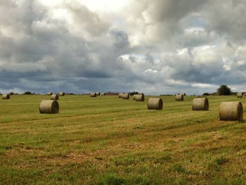 Hay bales on field against sky