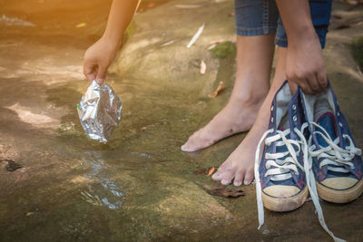 Low section of child standing on riverbank