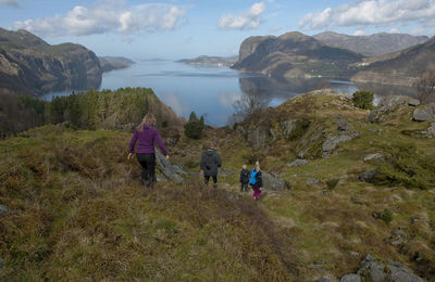 Rear view of people on mountain against sky