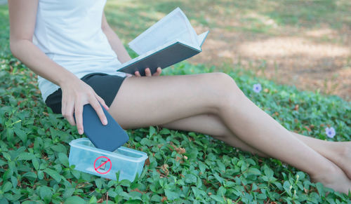 Low section of woman reading book