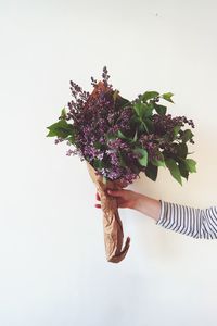 Woman holding flower bouquet against white background