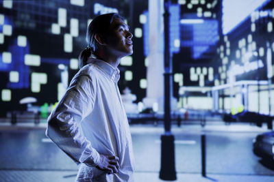 Side view of woman standing in city