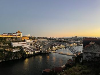 Bridge over river against sky during sunset