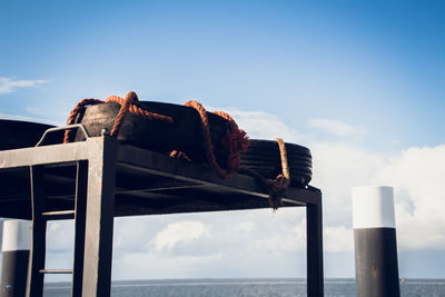 View of wooden post in sea against sky