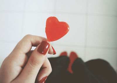 Cropped hand of woman holding heart shape candy