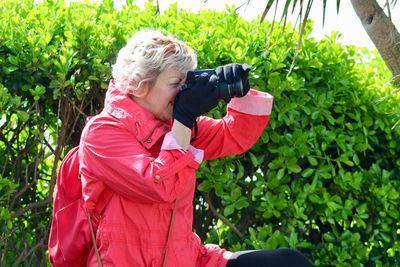 Senior woman photographing at park