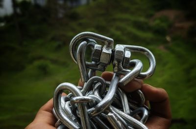 Close-up of person holding chain