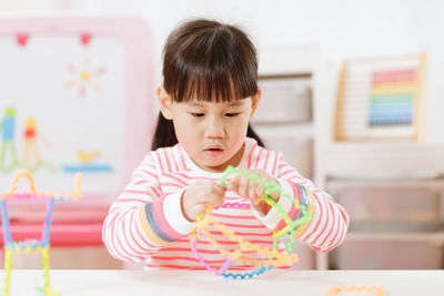 Young girl playing creative 3d shape toy for homeschooling