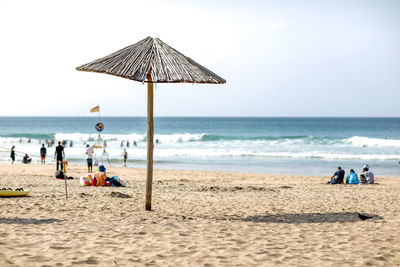 People on beach against clear sky