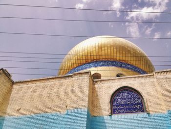 Low angle view of cross on building against sky