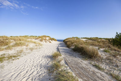 Surface level of footpath against clear sky