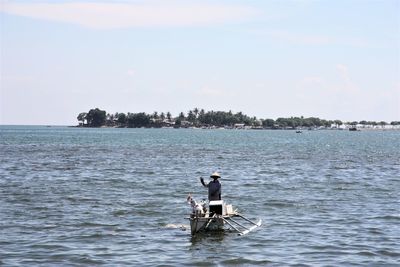 Man in sea against sky