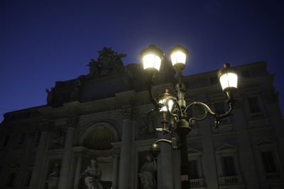 Low angle view of illuminated built structure against sky at night