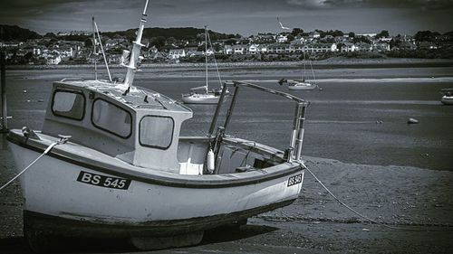 Boats moored at harbor against sky