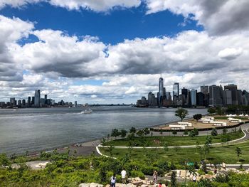 Scenic view of river by buildings against sky