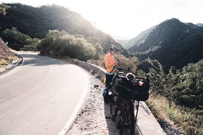 Rear view of man riding bicycle on road