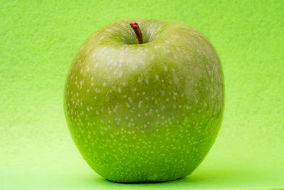 Close-up of apple against green background