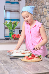 Teenage girl cutting cake