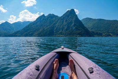 Man in boat on lake against mountains