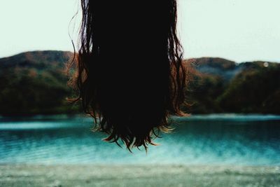 Woman hair hanging against lake