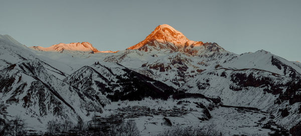 Scenic view of snowcapped mountains against clear sky