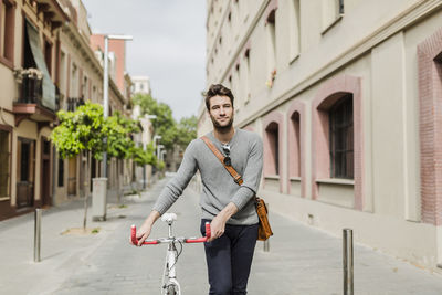 Young man pushing his bike