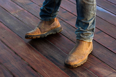 Low section of man standing on wooden floor