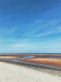 Scenic view of beach against blue sky