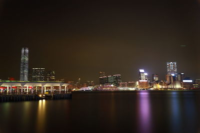 Illuminated buildings in city against sky at night