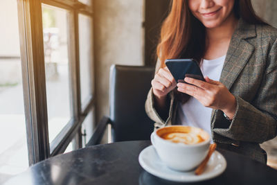 Midsection of woman holding coffee cup