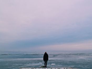 Woman standing on beach against sky