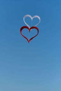 Low angle view of heart shape against clear blue sky