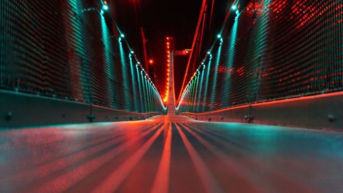 Surface level view of illuminated bridge at night