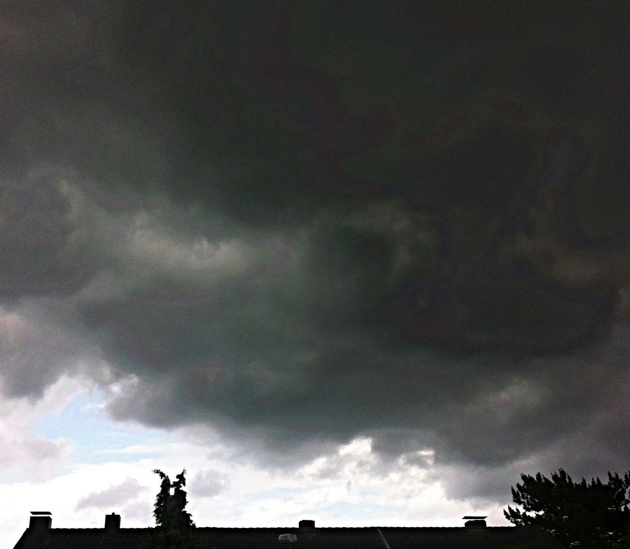 low angle view, sky, cloud - sky, built structure, architecture, cloudy, building exterior, statue, sculpture, art and craft, human representation, art, silhouette, cloud, creativity, high section, overcast, outdoors, animal representation