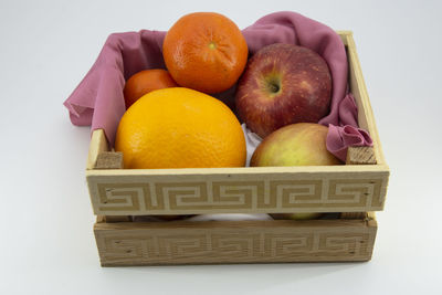 Close-up of fruits in basket against white background