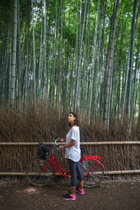 Full length of woman standing on field in forest