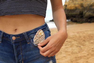 Midsection of woman standing at beach