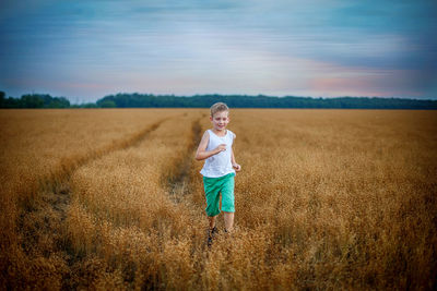 Full length of smiling young woman standing on field