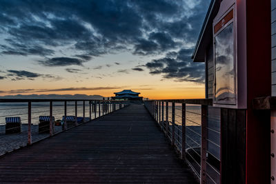 Pier over sea against sky during sunset